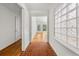 Hallway with hardwood and tile flooring leading to a bright living space, with a decorative block window at 2945 Cardinal Lake Cir, Duluth, GA 30096