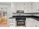 Stainless steel oven and range inset in white cabinets and dark countertops at 2945 Cardinal Lake Cir, Duluth, GA 30096
