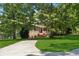 Charming brick home with lush landscaping, a long driveway, and mature trees providing shade at 4200 E 166 Hwy, Carrollton, GA 30116