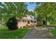 Attractive brick home featuring a full front porch, set among mature trees and green lawn at 4200 E 166 Hwy, Carrollton, GA 30116
