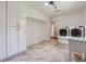 Spacious laundry room with white cabinets, marble tile flooring, utility sink, and modern washer and dryer at 4200 E 166 Hwy, Carrollton, GA 30116