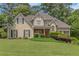 Charming two-story home featuring a well-manicured lawn and inviting front porch, set amongst mature trees and landscaping at 1605 Little Lisa Ln, Snellville, GA 30078