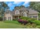 Elegant home showcasing lush landscaping, complemented by a covered front porch and traditional architectural details at 1605 Little Lisa Ln, Snellville, GA 30078