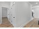 Hallway featuring modern floors, white doors, and an open view to other rooms in the house at 4190 Hosch Reserve Dr, Buford, GA 30519