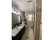 Bright bathroom featuring granite countertops, and a glass-enclosed shower with decorative tile at 1771 Kristi Dr, Lawrenceville, GA 30043