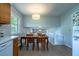 Bright dining area featuring wood floors, a modern light fixture, and views into the connected living space at 1831 Galilee Ct, Tucker, GA 30084