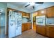 Functional kitchen with wood cabinets, white appliances, and a laminate floor at 1831 Galilee Ct, Tucker, GA 30084