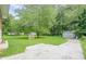 Spacious backyard with mature trees, green grass, utility shed with basketball hoop, and concrete patio at 2194 Freydale Se Rd, Marietta, GA 30067