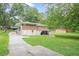 View of backyard showcasing lush lawn, patio, sports net, and the exterior of the brick home at 2194 Freydale Se Rd, Marietta, GA 30067