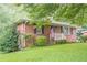Brick home with covered porch, green lawn and mature shrubs at 2194 Freydale Se Rd, Marietta, GA 30067