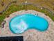 Aerial view of an in-ground kidney-shaped pool with a stone surround and lounge chairs at 3559 Turtle Cove Se Ct, Marietta, GA 30067