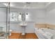 Elegant bathroom features a pedestal sink, soaking tub, and natural light at 3559 Turtle Cove Se Ct, Marietta, GA 30067