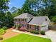 Charming two-story brick home with attached garage and well-manicured lawn surrounded by mature trees at 3559 Turtle Cove Se Ct, Marietta, GA 30067