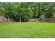 Spacious backyard with lush lawn, mature trees and a wooden fence for privacy and security at 2020 Bixby Se St, Atlanta, GA 30317