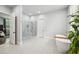 Bright bathroom featuring a glass shower, a soaking tub, and white tile flooring at 2020 Bixby Se St, Atlanta, GA 30317