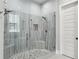 A shower with gray vertical tiles, a pebble floor, and multiple shower heads at 2020 Bixby Se St, Atlanta, GA 30317