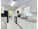 White kitchen with stainless steel appliances, granite counters, and adjacent laundry room at 1834 Buckeye Sw St, Atlanta, GA 30310