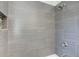Shower area with neutral textured tiles, shelf, and modern shower head at 1834 Buckeye Sw St, Atlanta, GA 30310