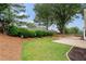 Private backyard showcasing mature trees, mulched flowerbeds, and a well-manicured lawn at 3549 Daventry Nw Ln, Kennesaw, GA 30144