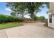 Brick patio extends to grass surrounded by shrubbery and trees; ideal for relaxation at 3549 Daventry Nw Ln, Kennesaw, GA 30144
