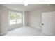Bright bedroom with neutral carpeting, a large window, and a modern door at 606 Goldsmith Ct # 114, Johns Creek, GA 30022