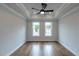 Bedroom with hardwood floors, tray ceilings, ceiling fan, and two large windows at 606 Goldsmith Ct # 114, Johns Creek, GA 30022
