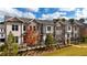 Charming three-story townhomes boast brick exteriors, black iron fences, and manicured landscaping at 606 Goldsmith Ct # 114, Johns Creek, GA 30022