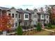 Brick townhomes with black fences, lush greenery, and colorful trees at 606 Goldsmith Ct # 114, Johns Creek, GA 30022