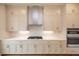 Contemporary kitchen boasts stainless steel appliances, range hood, and elegant white cabinetry at 606 Goldsmith Ct # 114, Johns Creek, GA 30022