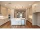 Bright kitchen with quartz countertops, stainless steel appliances, large island, and hardwood floors at 606 Goldsmith Ct # 114, Johns Creek, GA 30022
