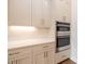 Close-up of modern kitchen appliances and neutral colored cabinets with stainless pulls at 606 Goldsmith Ct # 114, Johns Creek, GA 30022