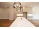Gourmet kitchen features stylish light fixtures, expansive island, and sleek white cabinetry at 606 Goldsmith Ct # 114, Johns Creek, GA 30022