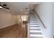 Open-concept living area with hardwood floors, staircase, and view into the kitchen at 606 Goldsmith Ct # 114, Johns Creek, GA 30022