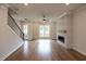 Open-concept living room with hardwood floors, fireplace, and staircase at 606 Goldsmith Ct # 114, Johns Creek, GA 30022