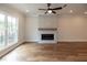 Bright living room with fireplace, hardwood floors, large window, and ceiling fan at 606 Goldsmith Ct # 114, Johns Creek, GA 30022
