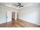 Spacious main bedroom with hardwood floors, a ceiling fan, and an ensuite bathroom with open entryways at 606 Goldsmith Ct # 114, Johns Creek, GA 30022