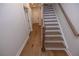 Staircase with painted risers and wood treads leading to a hallway with neutral walls at 606 Goldsmith Ct # 114, Johns Creek, GA 30022