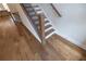 Staircase with hardwood floors, white risers, black metal railings, and natural wood handrail at 606 Goldsmith Ct # 114, Johns Creek, GA 30022