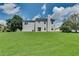Backyard with a well-maintained lawn and view of the home's exterior and chimney at 7550 Springmill Ct, Cumming, GA 30028