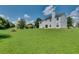 Large green backyard with mature trees surrounding the perimeter at 7550 Springmill Ct, Cumming, GA 30028