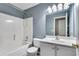 Bathroom features a shower-tub combo with a white vanity and modern lighting fixtures at 7550 Springmill Ct, Cumming, GA 30028