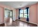 Bright bedroom with hardwood floors, a large window with blue curtains, and neutral walls at 7550 Springmill Ct, Cumming, GA 30028