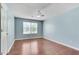 This bedroom features wood floors, a ceiling fan, and a bright window for natural light at 7550 Springmill Ct, Cumming, GA 30028