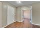 Cozy entryway with hardwood floors, a white front door, and a glimpse of a room beyond at 7550 Springmill Ct, Cumming, GA 30028