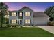 Charming two-story home with a well-manicured lawn, attached garage, and stone facade at 7550 Springmill Ct, Cumming, GA 30028