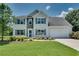 Charming two-story home featuring stone accents, a well-manicured lawn, and an attached two-car garage at 7550 Springmill Ct, Cumming, GA 30028