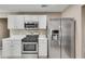 Kitchen showcasing stainless steel appliances, white cabinets, and ample counter space at 7550 Springmill Ct, Cumming, GA 30028