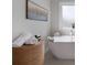 Bright soaking tub with a frosted glass window and woven basket at 197 Stafford Ln, Villa Rica, GA 30180