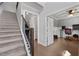 Hallway with staircase, dark wood railing, and adjacent room with a ceiling fan and desk setup at 197 Stafford Ln, Villa Rica, GA 30180