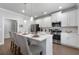 Modern kitchen with white cabinets, stainless steel appliances, quartz countertops, and a breakfast bar at 197 Stafford Ln, Villa Rica, GA 30180